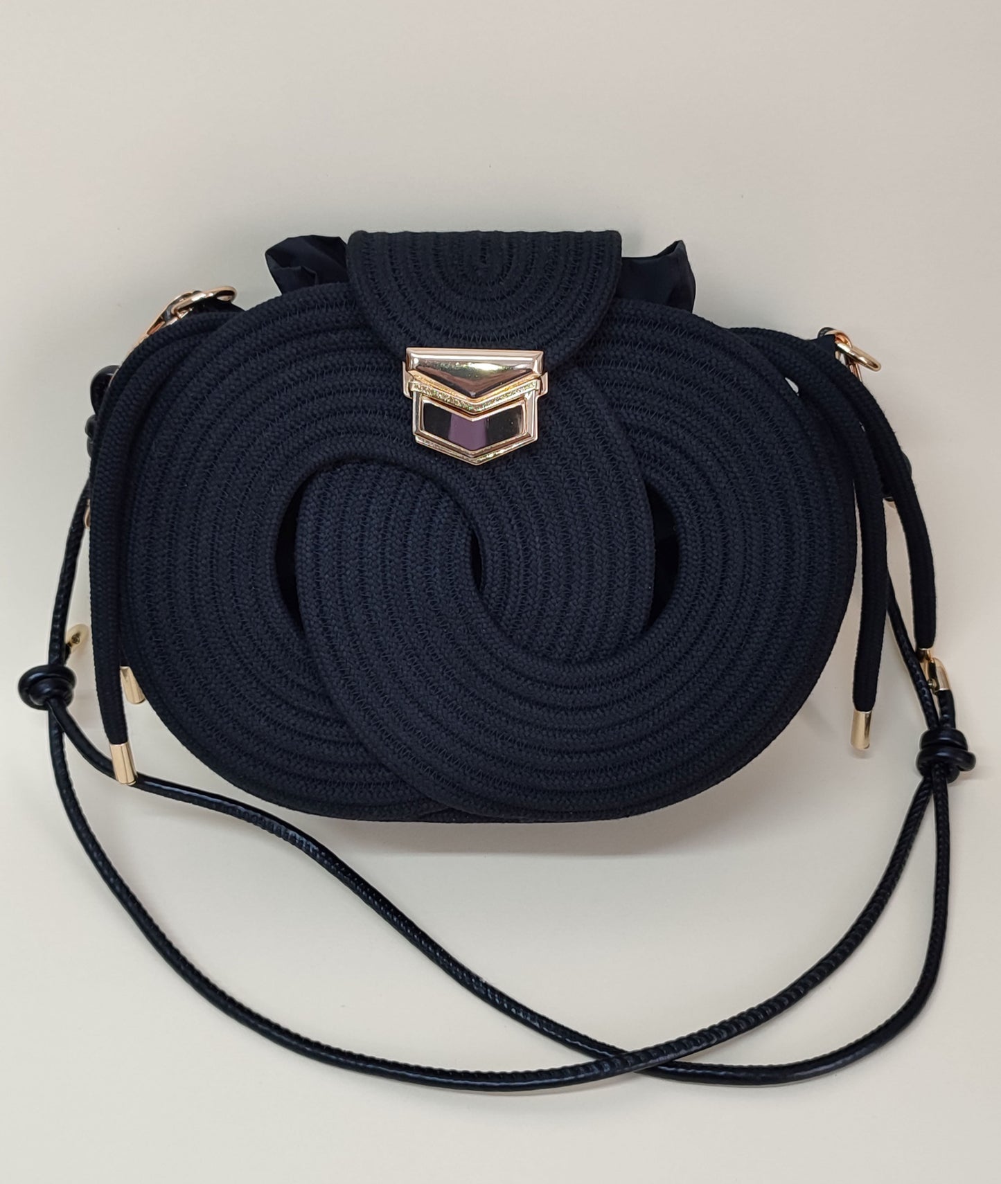 Nó Infinity bolsa artesanal preta com corda de algodão e fechamento metálico dourado
