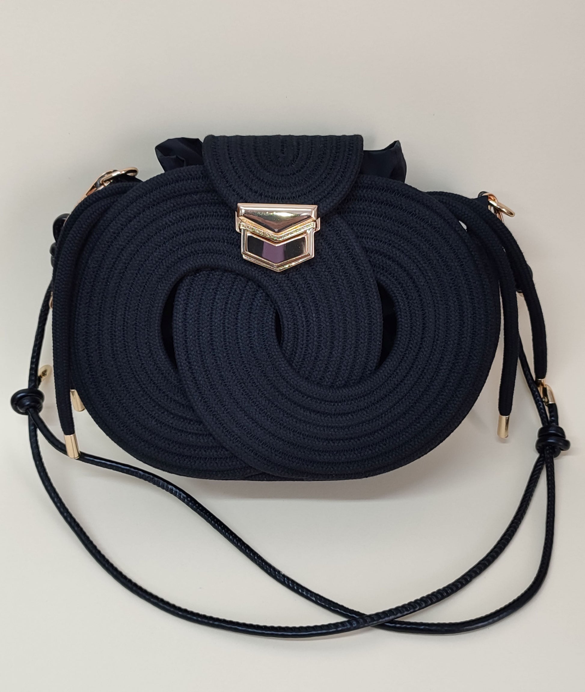 Nó Infinity bolsa artesanal preta com corda de algodão e fechamento metálico dourado