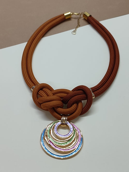 Colar artesanal modelo Marina com estrutura de cordão duplo e nudo marinheiro central simétrico com pendente decorativo na base.