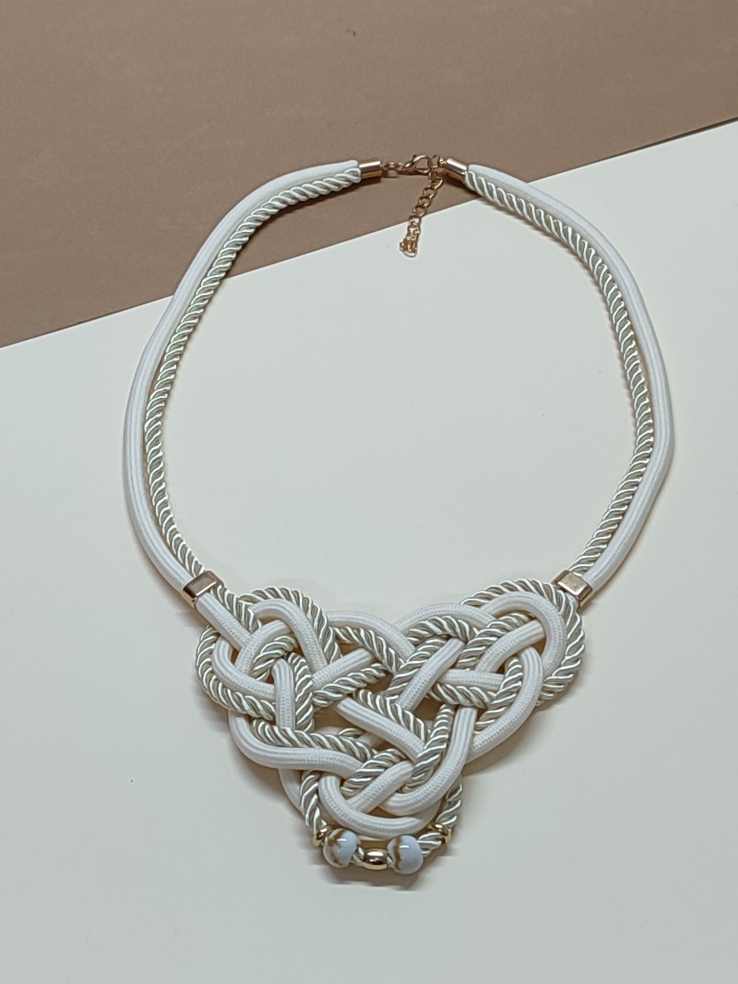 Colar de destaque modelo Knoten com intrincado trabalho artesanal de nós e cordões têxtil premium sobrepostos, criando uma estrutura geométrica elegante.