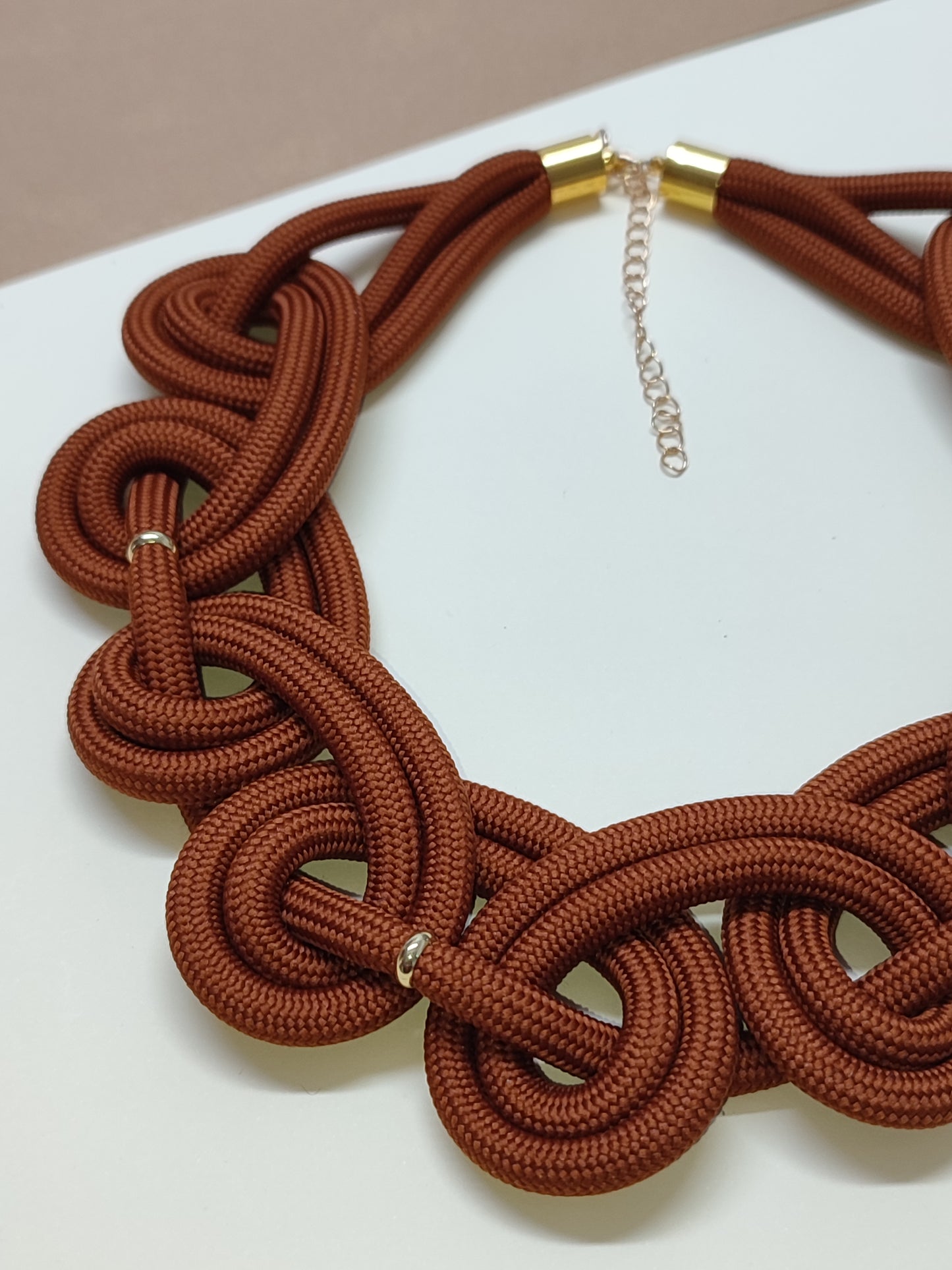 Maxicolar estilo gola artesanal modelo Imperial com padrão contínuo de laços em espiral estruturados que cobrem todo o decote.