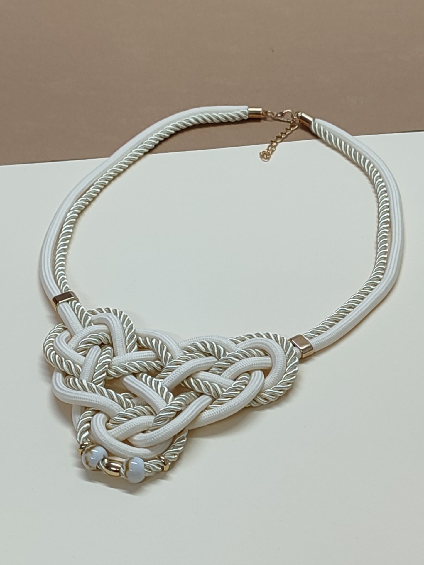 Colar de destaque modelo Knoten com intrincado trabalho artesanal de nós e cordões têxtil premium sobrepostos, criando uma estrutura geométrica elegante.