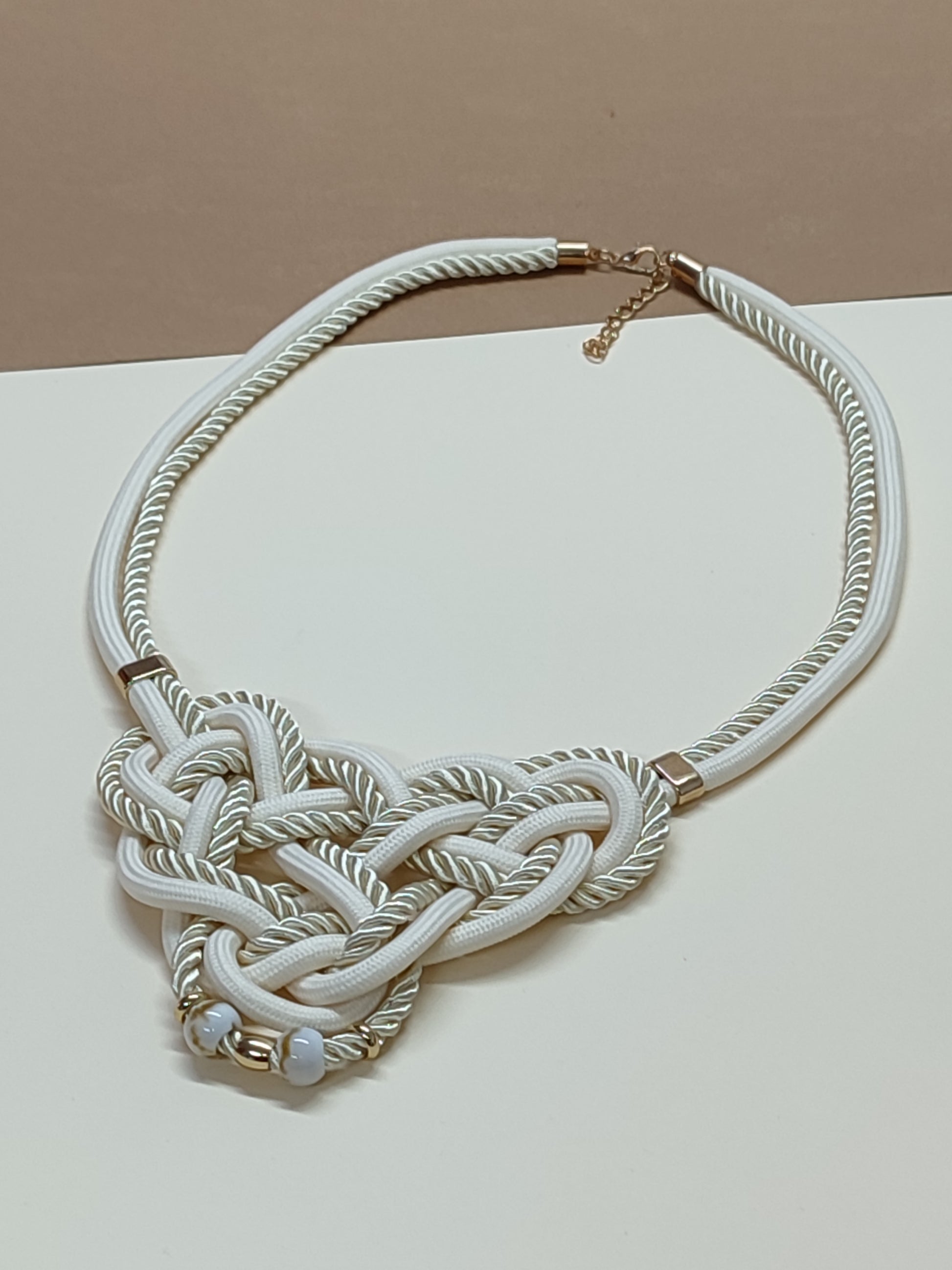 Colar de destaque modelo Knoten com intrincado trabalho artesanal de nós e cordões têxtil premium sobrepostos, criando uma estrutura geométrica elegante.